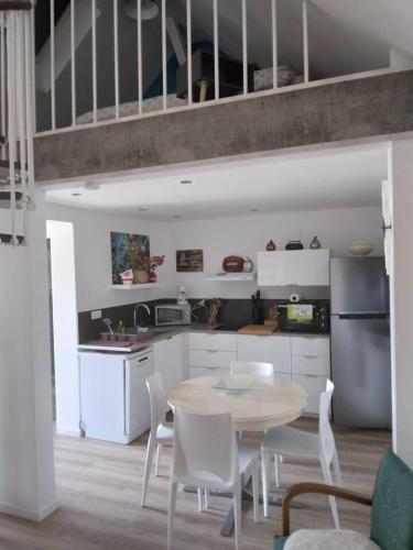 une cuisine avec une table et des chaises dans une pièce dans l'établissement Appartement cosy Wintzenheim + terrasse, à Wintzenheim