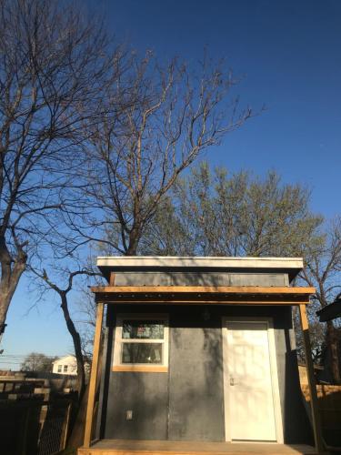 a small building with a window in front of trees at ATX Tiny House in Austin