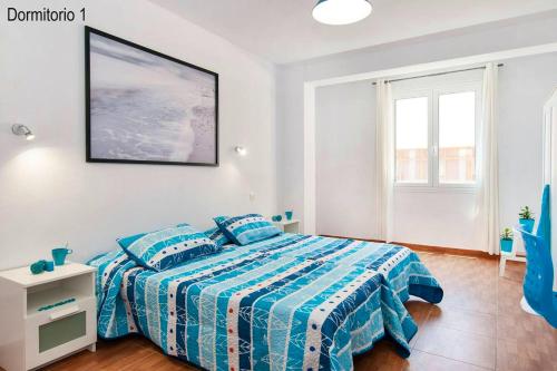 a bedroom with a bed with a blue comforter at 2 bedrooms appartement with wifi at Las Palmas de Gran Canaria in Las Palmas de Gran Canaria
