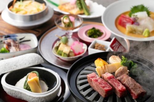 uma mesa com pratos de comida numa grelha em KAMENOI HOTEL Fukui em Fukui