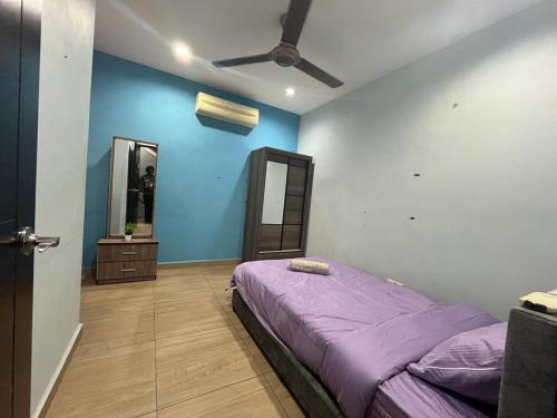 1 dormitorio con cama morada y ventilador de techo en Mega Homestay, en Butterworth