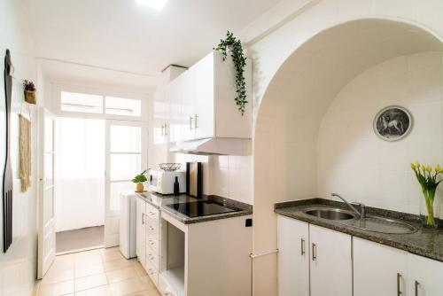 eine Küche mit weißen Schränken und einem Waschbecken in der Unterkunft One bedroom apartement with wifi at Porto 3 km away from the beach in Porto