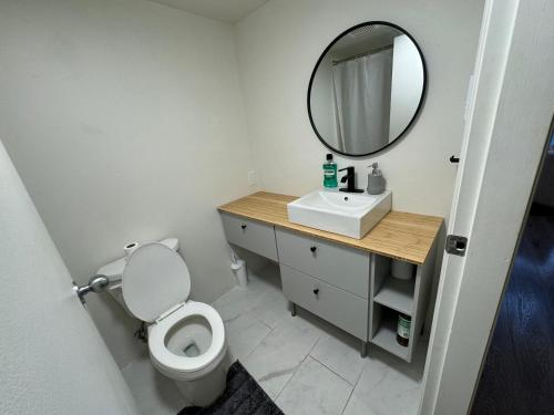 bagno con servizi igienici bianchi e specchio di LUXURY LOFT IN DOWNTOWN VANCOUVER a Vancouver