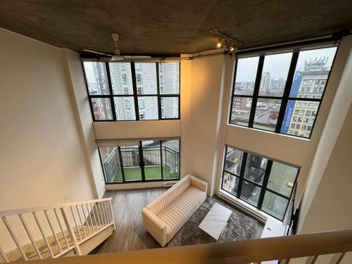an overhead view of a living room with large windows at LUXURY LOFT IN DOWNTOWN VANCOUVER in Vancouver