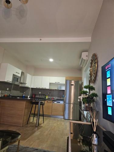 eine Küche mit weißen Schränken und einem Kühlschrank aus Edelstahl in der Unterkunft Comfortable luxury apartment in Istanbul