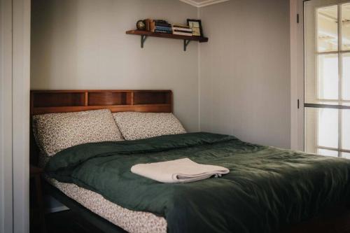 GheerullaにあるGheerulla Placeのベッド(緑の毛布、白いシャツ付)