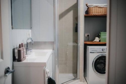 a bathroom with a sink and a washing machine at Gheerulla Place in Gheerulla