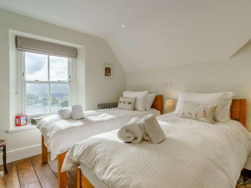 two white beds in a room with a window at 5 Bed in Crickhowell 90053 in Crickhowell