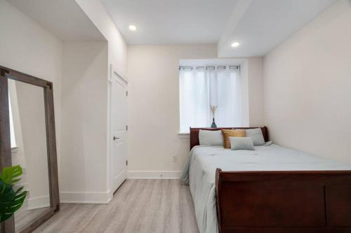 a white bedroom with a bed and a window at Luxurious & Spacious 3Bed/3Bath with Outdoor Patio in Philadelphia