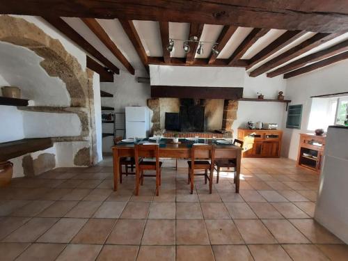 een keuken met een tafel en stoelen in een kamer bij La petite maison de Chavroches - proche du Pal 