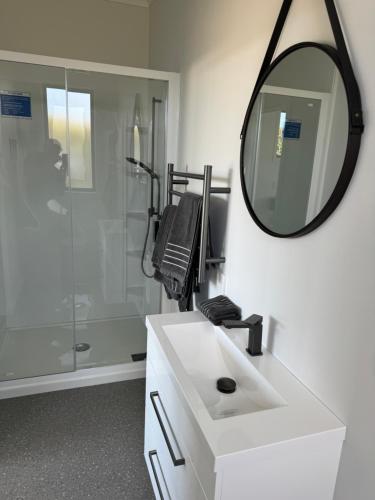 a bathroom with a white sink and a mirror at Cashmere B&B in Masterton