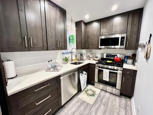uma cozinha com armários de madeira e um forno com placa de fogão em Eleni’s Charming Studio em North Beach