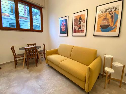 a living room with a yellow couch and a table at La Cadrega in Milan