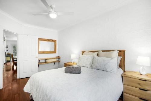 1 dormitorio con cama blanca y mesita de noche de madera en Nannup Bush Retreat, en Nannup