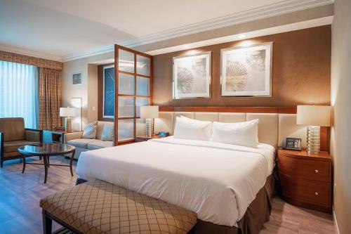 een slaapkamer met een groot bed en een woonkamer bij No Resort Fee StripView Balcony+ Free Valet+ Pool in Las Vegas
