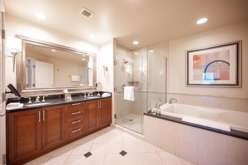 een badkamer met een bad, een wastafel en een douche bij No Resort Fee StripView Balcony+ Free Valet+ Pool in Las Vegas