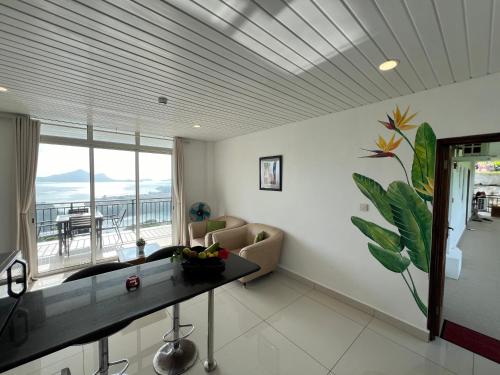 a living room with a table and a couch and a window at Creole Pearl Self-Catering in Victoria