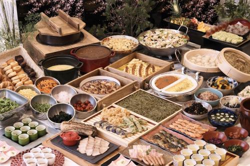 京都市にあるアルモントホテル京都のテーブルの上に並ぶ様々な種類の料理を楽しめます。