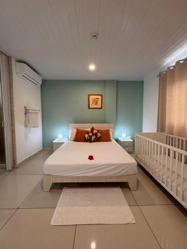 a bedroom with a bed and a crib in it at Creole Pearl Self-Catering in Victoria