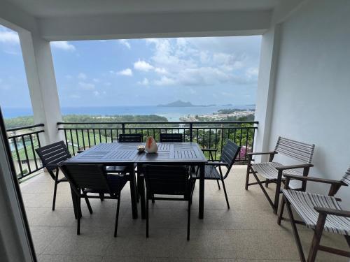 a table and chairs on a balcony with a view at Creole Pearl Self-Catering in Victoria
