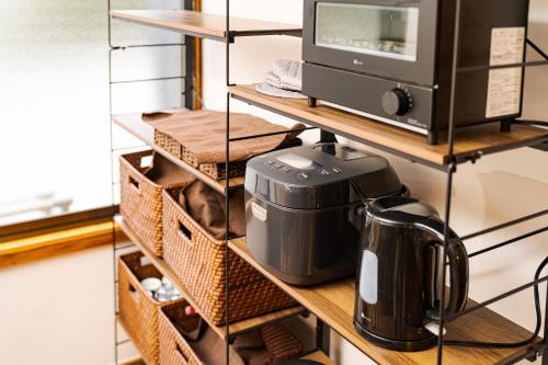 estante de cocina con cafetera y microondas en Kamekawa Yukari Ann en Beppu