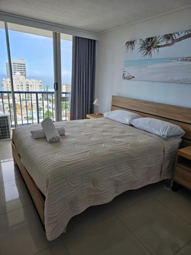 a bedroom with a large bed and a large window at Centrepoint Resort in Gold Coast