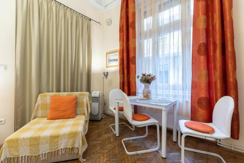 a bedroom with a bed and a table and a window at Harmony & Cute - central apartments in Budapest