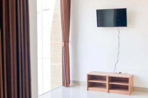 uma sala de estar com uma televisão e uma mesa de madeira em CK Residence Syariah em Jomblang