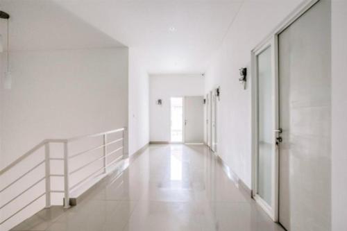 um corredor de um edifício com paredes brancas e pisos brancos em CK Residence Syariah em Jomblang