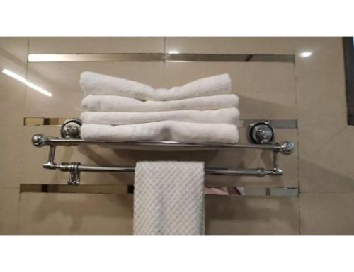 a pile of towels on a towel rack in a bathroom at Hotel The Tulip ,Chandigarh in Chandīgarh