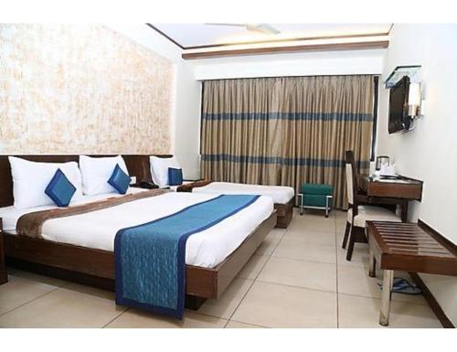 a hotel room with a bed and a desk and a desk at Hotel The Tulip ,Chandigarh in Chandīgarh