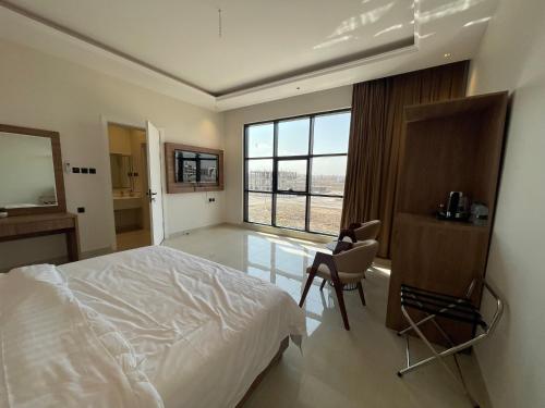 a bedroom with a bed and a desk and a window at مخطط القصر أو وادي مذينب ، خلف جرير in Al Madinah