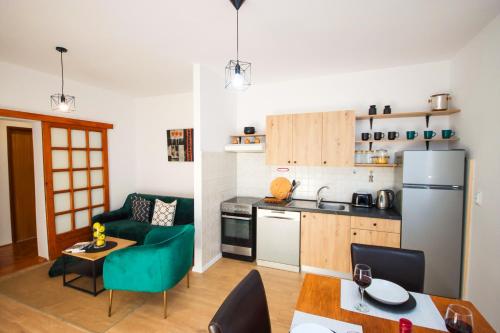 cocina y sala de estar con sofá verde y mesa en Apartments Mira, en Cavtat