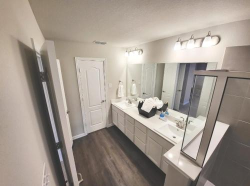 Baño blanco con lavabo y espejo en Luxury 3 bedrooms 3 bathrooms, en Flower Mound