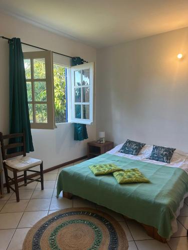 een slaapkamer met een bed, een stoel en een raam bij Villa Nicky in Le Tampon