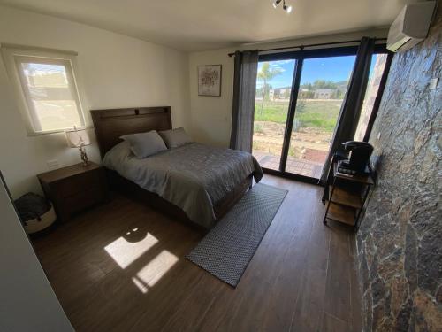 um quarto com uma cama e uma grande janela em Estancia Cataviña Valle de Guadalupe em Valle de Guadalupe