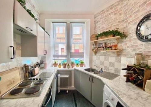 a kitchen with a sink and a clock on the wall at Entire, main door, pet friendly, home away from home, East Ayrshire in Newmilns