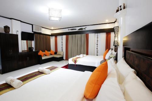 een hotelkamer met 2 bedden en een televisie bij Coron Bancuang Mansion in Coron