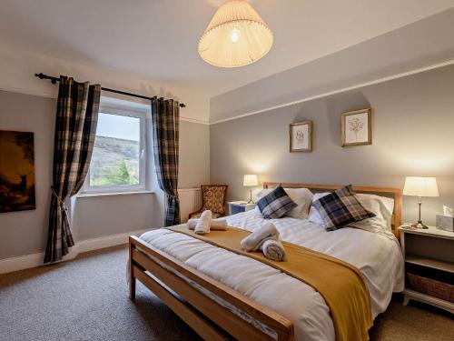 a bedroom with a large bed with a window at 3 Bed in Alston 89994 in Slaggyford