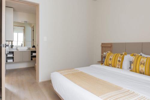 a bedroom with a bed with yellow and white pillows at Lerma Dos Seis Cuatro in Mexico City