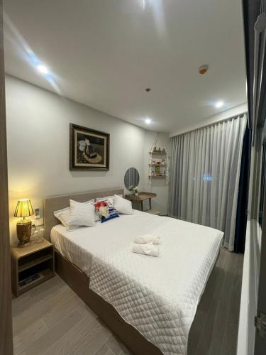 1 dormitorio con 1 cama grande con sábanas blancas en Premium 2pn The Sóng 5 Sao Homestay Khánh Vân, en Vung Tau