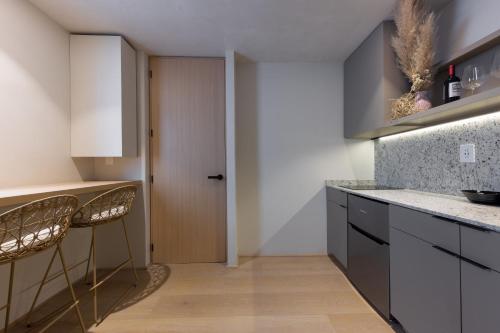 a kitchen with two bar stools and a door at Lerma Dos Seis Cuatro in Mexico City