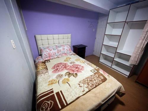 a bedroom with a bed with a floral bedspread at Departamento Céntrico, cómodo y acogedor in Puno