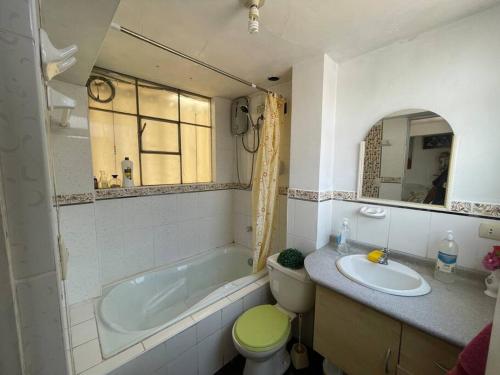 a bathroom with a tub and a toilet and a sink at Departamento Céntrico, cómodo y acogedor in Puno