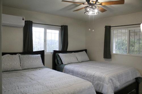 a bedroom with two beds and a ceiling fan at Hummingbird Hill - Entire Cabin in Dunlap