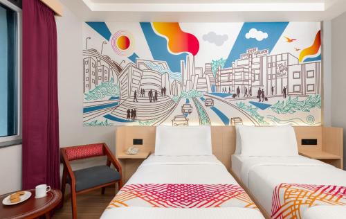 Cette chambre comprend 2 lits et une fresque murale. dans l'établissement Ginger Durgapur, à Durgapur