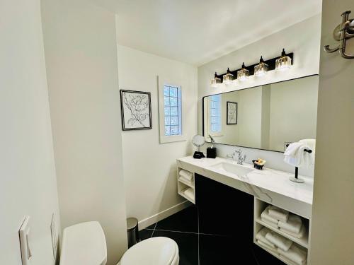 a white bathroom with a sink and a mirror at Bespoke Inn Flagstaff in Flagstaff