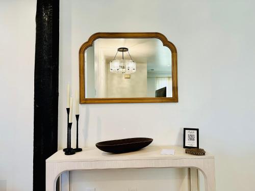 a mirror over a white table with a bowl on it at Bespoke Inn Flagstaff in Flagstaff
