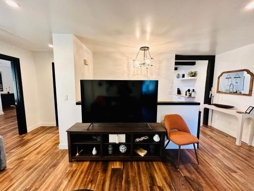 a living room with a flat screen tv and a chair at Bespoke Inn Flagstaff in Flagstaff