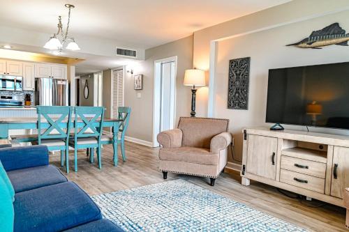 a living room with a couch and a dining room at Direct Oceanfront Magic at Sea Marsh w Pool in Myrtle Beach